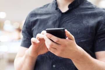 Image of a man`s hands using a smart phone, close up.