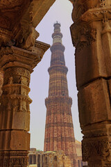 A view of Qutub Minar through old building pillars giving a glimpse of old archtectural heritage