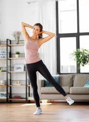 sport, fitness and healthy lifestyle concept - smiling young woman exercising at home