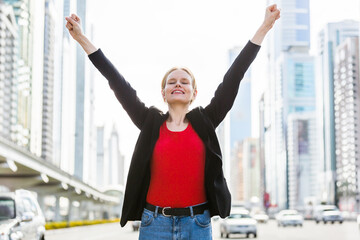 Business success. Happy businesswoman celebrating her achievements in the city. 