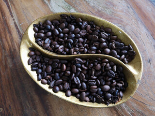 Coffee beans roasted in a cup on a wooden table