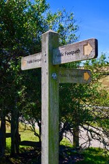 A wooden sign stating Public footpath in the countryside