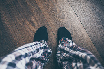 feet from above on wooden floor in pajamas