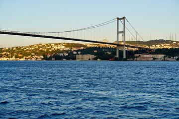 Tourist boats sail under the bridge in Istanbul. Traveling on the Bosphorus. Panoramic view, View of the First Bosphorus Bridge sailling Bosporus.