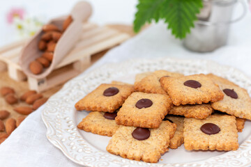 Cookies with almonds and chocolate with almond seeds on a light background. Beautiful homemade pastries. Selective soft focus.