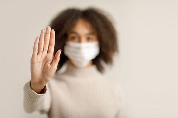Stop worldwide COVID-19 epidemic. Focus on hand of african american woman in protective mask