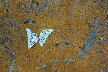Broken toy butterfly on a concrete slab.