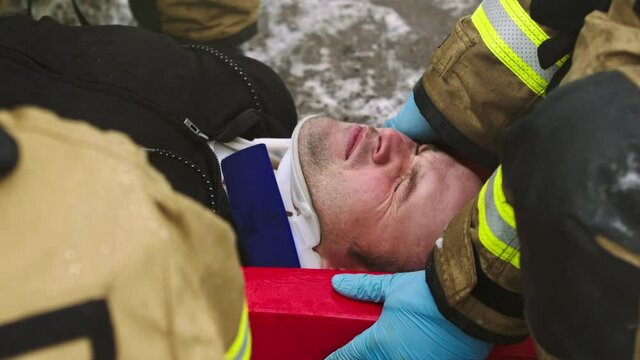 Firefghters lifting injured man. Rescue after car crash accident. High quality 4k footage