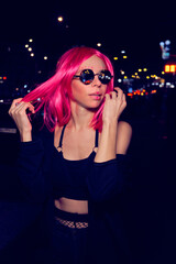 Young woman with pink hair at night
