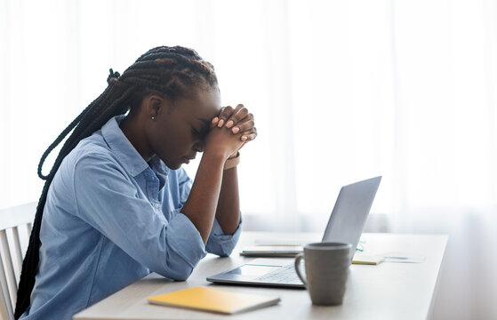 Business Problems. Depressed Black Businesswoman Sitting At Workplace In Office, Touching Head