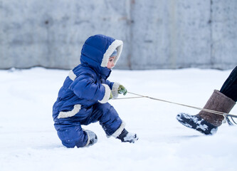 Fototapeta na wymiar Little girl sledding adult woman in winter on snow