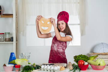 Baking process. kid cooking food in kitchen. choosing a career. little helper with funny dough. culinary and cuisine. happy childhood. happy child wear cook uniform. chef girl in hat and apron