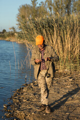 Naklejka premium Fisherman standing on the riverside and trying to catch a fish. Sport, recreation, lifestyle.