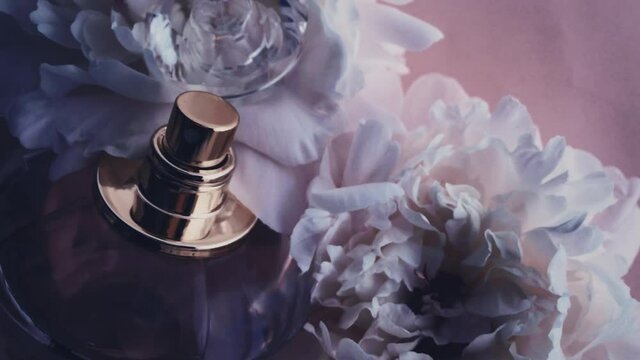 Purple perfume bottle with peony flowers, chic fragrance scent as luxury cosmetic, fashion and beauty product background, stock footage