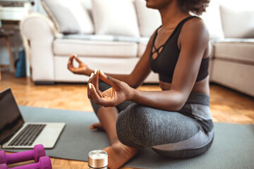 Shot of an attractive young woman practicing yoga at home. Shot of a fit young woman meditating at...