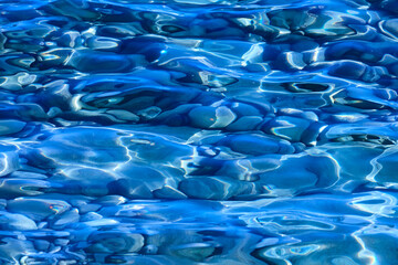 Pebble stone blue reflections on the water. Nature background. Relax