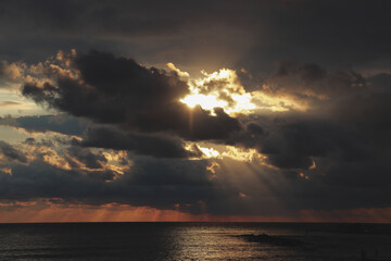 Sunset over the sea, sunshine coming through the clouds