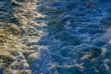 Bubbling blue waves of traces of tourist cruise ships passing on the Bosporus. Water trail foaming behind a passenger ferry boat in Bosphorus, Istanbul, Turkey.