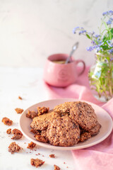 Homemade oatmeal cookies on a plate and with a mug of tea. The concept of a beautiful breakfast.
