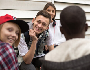 group of modern teens chatting in the yard