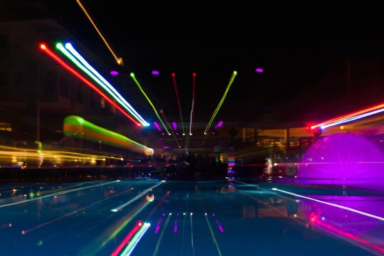 motion blur of multicolor open air disco lights at the pool