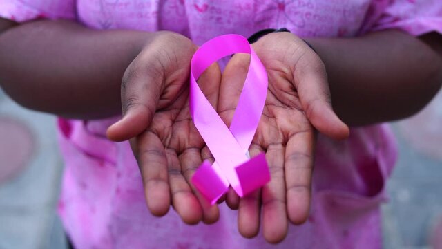 4k video of a black hands holding a pink ribbon in hands-concept on world cancer day