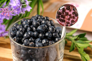 Homemade lollipops made from natural dehydrated bilberry on a white wooden background. Healthy vegan vegetarian food with no sweets.