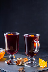 Mulled wine on a slate board. Two glasses of hot mulled wine and ingredients. Christmas hot drink with wine and honey