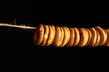 Bagels on a rope on dark background.