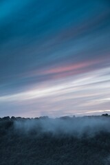Fototapeta premium Abend Nebel über Landschaft mit bewaldetem Tal