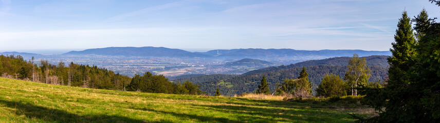 Fototapeta premium Zywiec Basin (Valley) panorama in Beskid Mountains, Poland, with green forests, meadows and Zywiec Lake, seen from the hill.