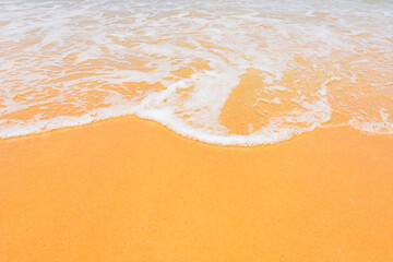 The smooth sandy beach with beautiful waves as the background.