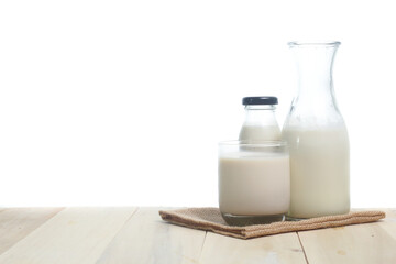 Milk in glass and in jar on table isolated on white background