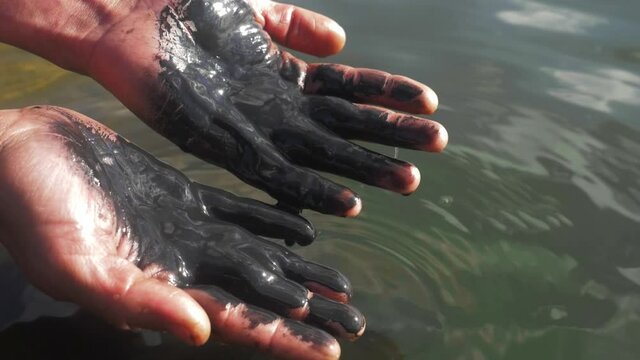 Slick industry oil fuel spilling water pollution. environmental pollution - research. oil in human hands, ecology anf environment.