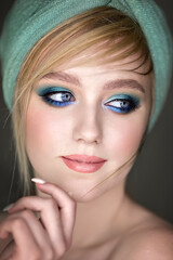 Close-up portrait of a girl with blue makeup.