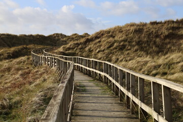 Fototapeta na wymiar The wooden boardwalk leading through the dunes to the beach at Dyffryn Ardudwy, Gwynedd, Wales, UK.