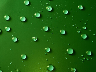 Water drops on green background.