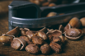 Nutcracker, whole nuts, shelled nuts and shells. Corylus avellana. Macro photo, close up, on wooden table.