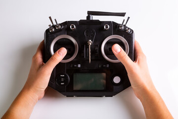 Black remote control panel and hands on controls for drone. Top view on white background. Horizontal orientation. High quality photo © Sander Studio