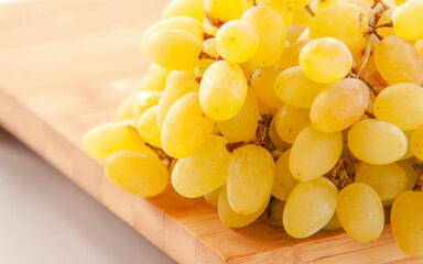 yellow grape close up on wooden board