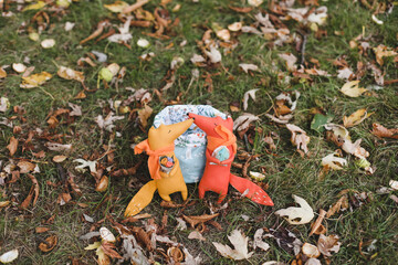 Cute little toys sit in a basket in the autumn garden. Childhood, baby, holiday, people, hobby, emotions concepts