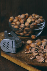 Nutcracker, whole nuts, shelled nuts and shells. Corylus avellana. Close up, on wooden table.