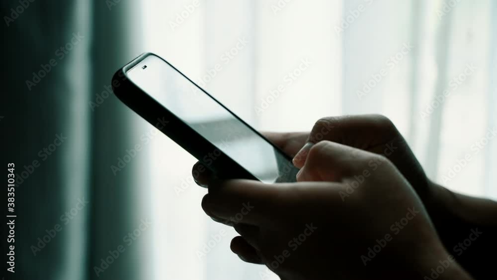 Poster man using smartphone in the living room at home, close-up of hand typing message