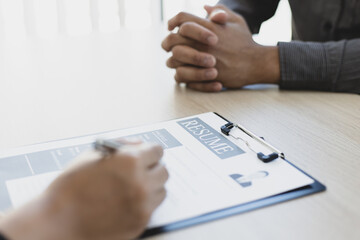 HR head is interviewing a young man's job application in a private room.