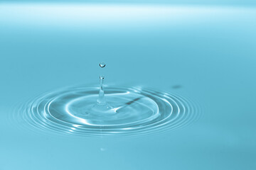 Naklejka na ściany i meble Drop of water drop to the surface. Waves on the surface of the water from a collision