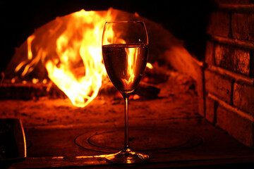 
Glass of wine on the background of the hearth .