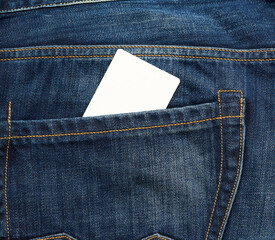 empty white paper card is in the back pocket of blue jeans