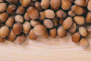 Pile of nuts. Whole nuts. Corylus avellana. Macro photo, close up, top view on wooden table.