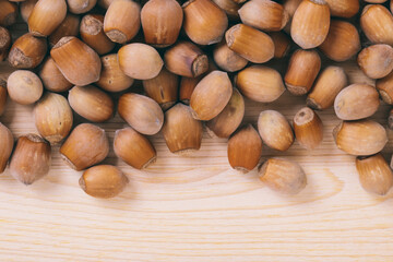 Pile of nuts. Whole nuts. Corylus avellana. Macro photo, close up, top view on wooden table.
