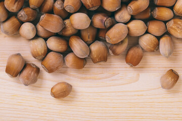 Pile of nuts. Whole nuts. Corylus avellana. Macro photo, close up, top view on wooden table.